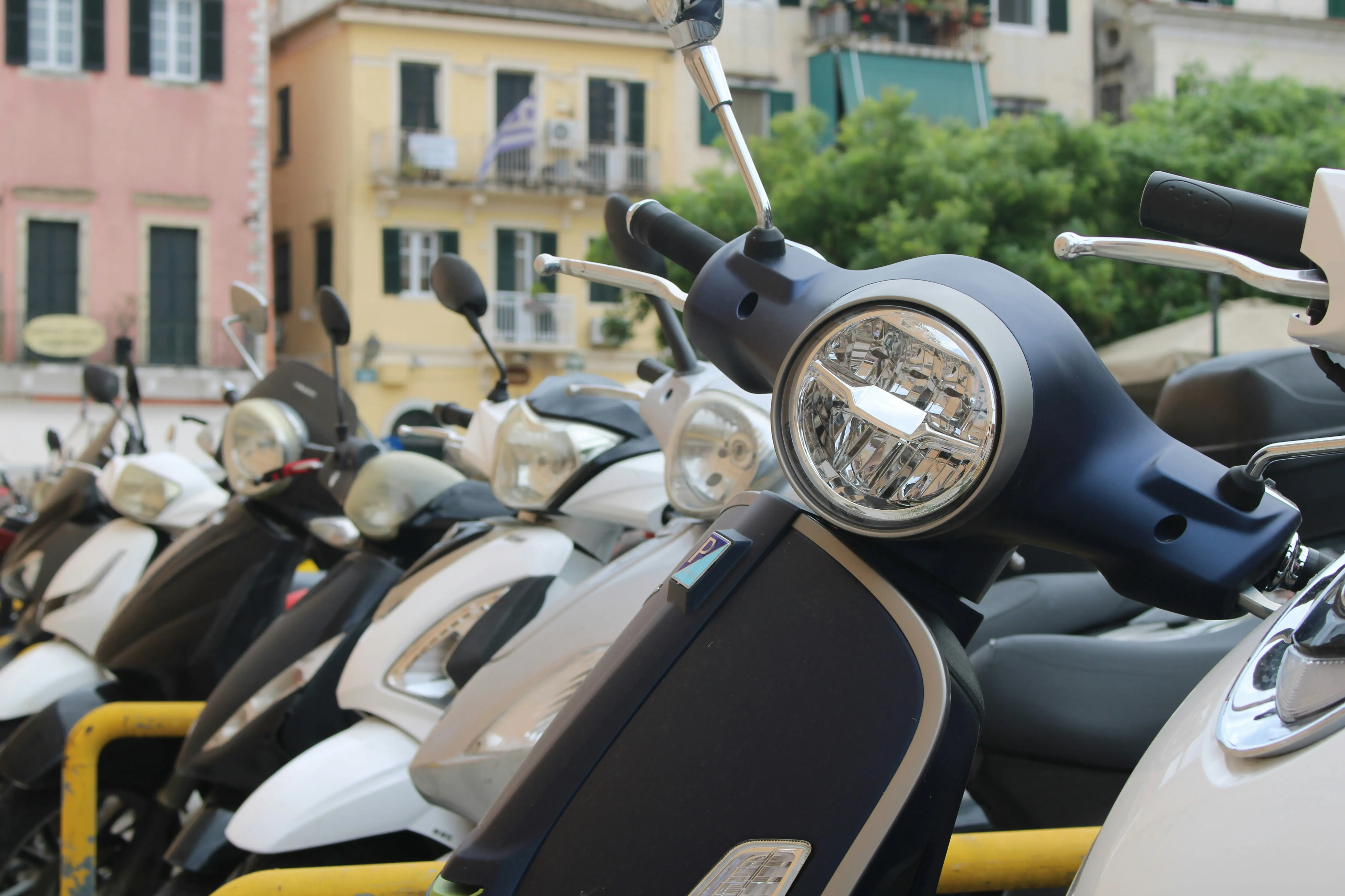Several parked scooters in front of buildings
